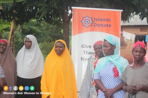 Widows stand by an Islamic Donate Charity banner for emergency aid. Empowering women and girls through cryptocurrency donations such as BTC, ETH, SOL, TRX, and USDT.