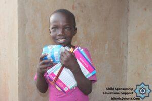 Smiling child holds school supplies, including notebooks and toiletries, representing educational support made by crypto donations via RLUSD.