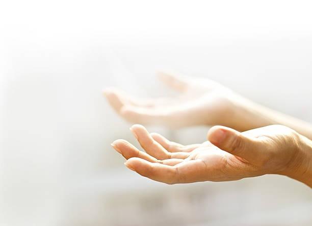Two hands open and reaching upwards in a gesture of prayer or supplication, with the background softly blurred. Donation via Bitcoin processing.