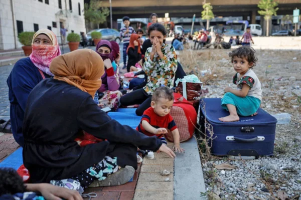 Displaced families in Dahiyeh, Beirut endure hardship, awaiting aid. The scene depicts vulnerable children and women seeking shelter. Your donation supports vital relief efforts, processed securely via USDT.