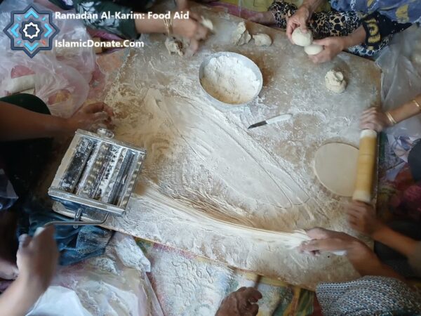 Ramadan food aid preparation: women make dried noodles from flour using a pasta maker and rolling pin. Crypto donations such as Solana fund this food security project.